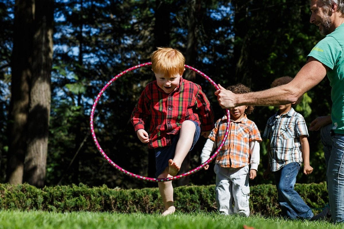 boy jumping through hula hoop realizado por adultos